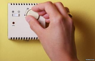 Hand on thermostat