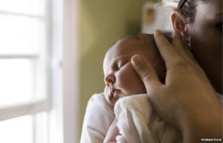 Close-up of mother cradling baby