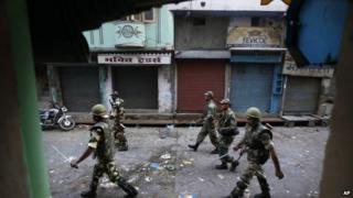 Indian army soldiers patrol during a curfew after deadly clashes between Hindus and Muslims in Muzaffarnagar on 9 Sept 2013