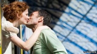 Couple kissing at a train station