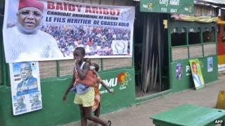 Child walks past campaign posters
