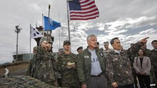 South Korean Defence Minister Kim Kwan-jin (right) points out a location in North Korea to US Secretary of Defence Chuck Hagel from Observation Point Ouellette during a tour of the Demilitarized Zone (DMZ), the military border separating the two Koreas, in Panmunjom, South Korea, on 30 September 2013
