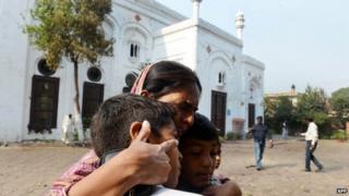 A Pakistani Christian woman embraces children as she mourns the death of relatives at the suicide bombing site at All Saints church in Peshawar on September 23, 2013