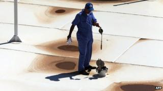 A Libyan oil worker from the Libyan National oil and gas company walks at the the Zawiya oil installation (22 Aug 2013)