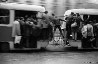 Photo of man straddling trams in Bucharest