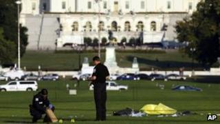 Police investigators gather evidence near where officials said a man set himself on fire, on the National Mall 4 October 2013