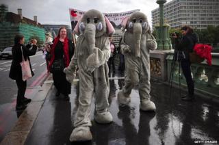 Two protesters in elephant costume march across Westminster Bridge