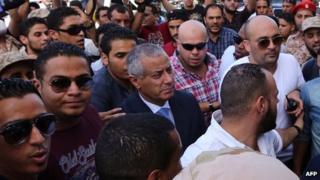 Libyan PM Ali Zeidan (centre) following his release by militiamen in Tripoli on 10 October 2013
