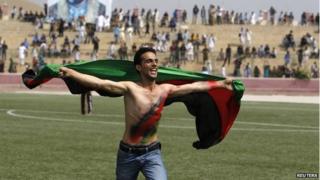 An Afghan football fan runs with the national flag as he celebrates their national football team"s victory in the South Asian Football Federation Championship, at the Kabul stadium September 12, 2013.
