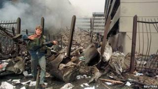 A US embassy official secures the area around the embassy building after a powerful bomb blast in Nairobi (7 August 1998)