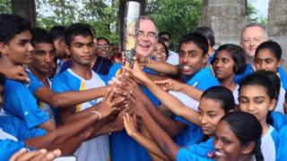 Children from the nine provinces of Sri Lanka hold the baton with John Rankin, British High Commissioner