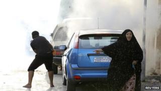 Woman fleeing tear gas in Maqusha