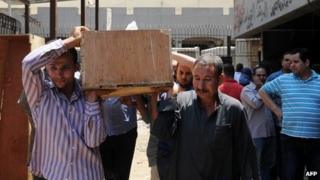 Men carry the coffin of an Islamist detainee who died when tear gas was fired into a transport vehicle (19 August 2013)