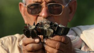 An Indian villager shows shells, that locals say are being fired from the Pakistan, at a village in Samba sector, about 75km (47 miles) from Jammu on October 21, 2013