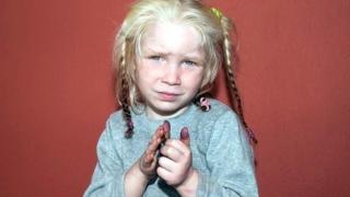 Blonde haired girl facing camera