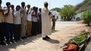 People pray over the body of slain Somali journalist, Abdihared Osman Adan, who was working with Radio Shabelle, before he is laid to rest in the Somali capital, Mogadishu (18 January 2013)