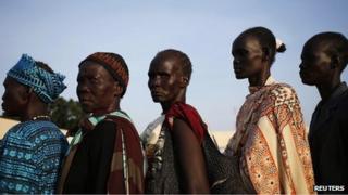 Women wait to vote in front of a polling station located at a school during a referendum in the town of Abyei on 27 October 2013