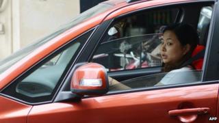 A woman drives her car on a street in Shanghai on October 30, 2013