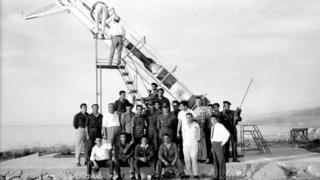 Students stand in front of the Cedar III rocket in 1962