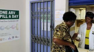 A woman receives medication at a pharmacy north of Johannesburg, South Africa