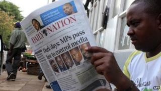 A man reading a paper about Kenya's new media bill, 1 November 2013