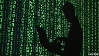Man with laptop in front of binary code projection (file photo)