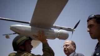 File image of an Israeli soldier holding up a 'Skylark' unmanned drone as part of a demonstration for Israel's Defence Minister Moshe Yaalon, centre, on 9 July 2013