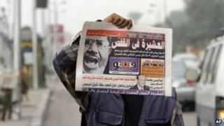 An Egyptian newspaper vendor displays a copy of a morning newspaper fronted by a picture of Egypt's ousted President Mohammed Morsi in Cairo