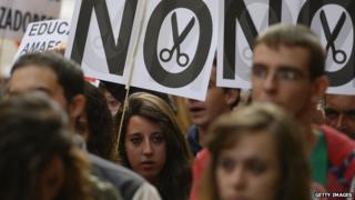 Students hold placards during a demonstration in Madrid in October 2013 against cuts in education spending