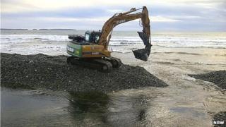 Digger working to remove sand and shale on Pembrokeshire beach