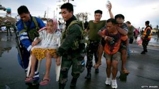 An elderly lady and an injured man are evacuated after Typhoon Haiyan