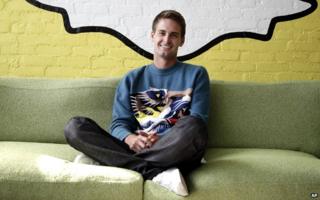 Evan Spiegel sits under the Snapchat logo