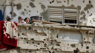 Children on the balcony of a building damaged during the November 2012 Israel-Gaza conflict (13 November 2013)