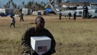 A US Marine loads supplies bound for typhoon victims onto a helicopter.