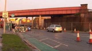 Cars by railway bridge