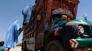 Afghan refugees board a truck in Kabul, June 2013
