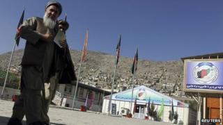 Afghan men walk near a registration area for the Loya Jirga, in Kabul