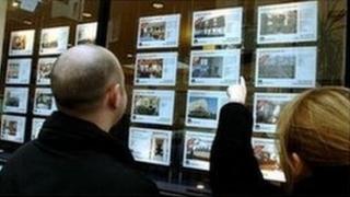 Couple looking in estate agent's window