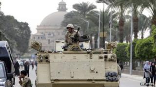 A soldier in an armoured personnel carrier at the main gate of Cairo University