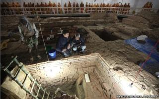Archaeologists Robin Coningham (left) and Kosh Prasad Acharya direct excavations within the Maya Devi Temple, while Thai monks meditate