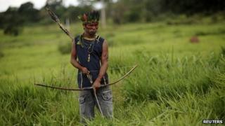 A member of the Guarani Nandeva tribe stands watch at a roadblock they built to keep farmers out, November 22, 2013
