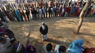 Indian voters wait in queues to cast their votes for the Delhi state election in New Delhi, India, Wednesday, Dec. 4, 2013