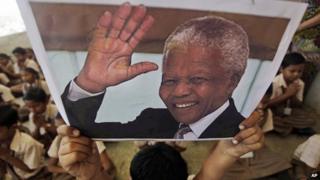 Boy holding up picture of Nelson Mandela