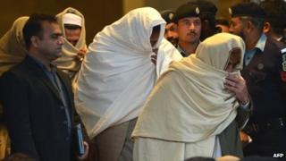 Pakistani policemen escort newly-identified missing persons as they leave the Supreme Court building in Islamabad