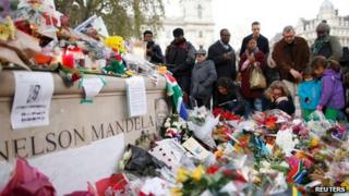Floral tributes by Nelson Mandela statue in Parliament Square on 7 December 2013