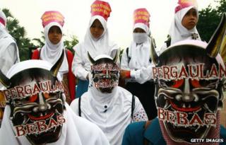 Indonesian Muslim women from Hizb ut-Tahrir Indonesia protest against condoms