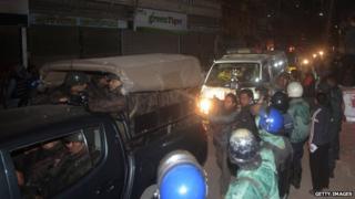 Ambulances escorted by the Bangladesh border guard carry the body of Mullah in Dhaka on December 12, 2013