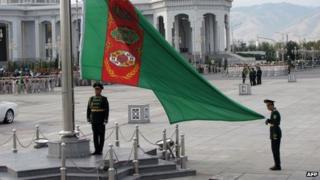 Soldiers raise the national flag during a military parade marking Turkmenistan's Independence Day (27 October 2013)