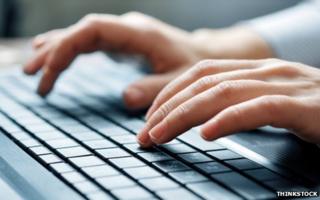 Hands typing on computer keyboard