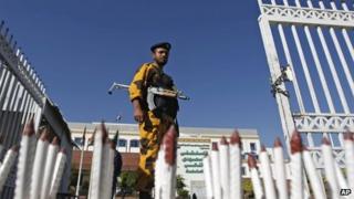 A policeman stands guard at the gate of a hospital where a Japanese diplomat is being treated in Sanaa